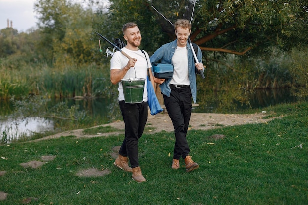 Friends is ready to fishing. Men holding a fishing equipment