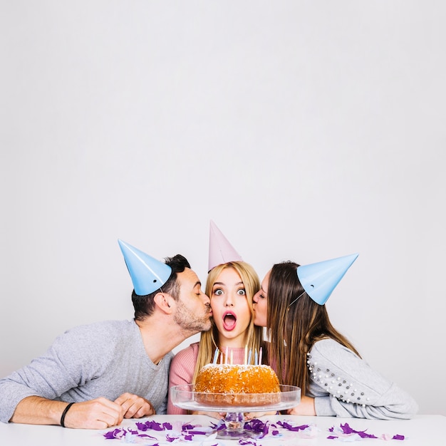 Free photo friends kissing girl at birthday