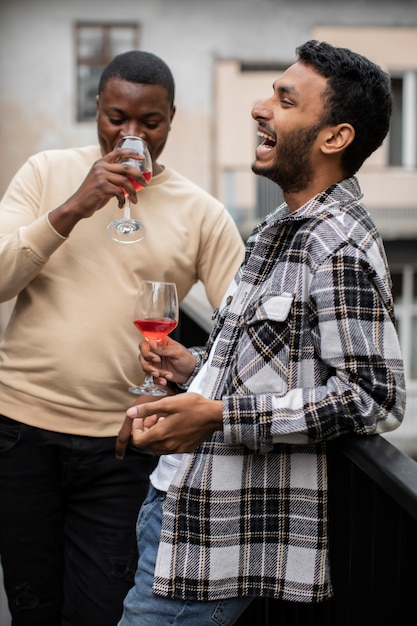 友達が笑ってグラスワインを飲む