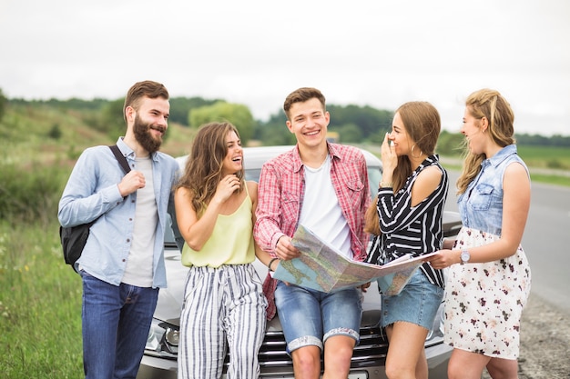 Friends laughing at man holding map