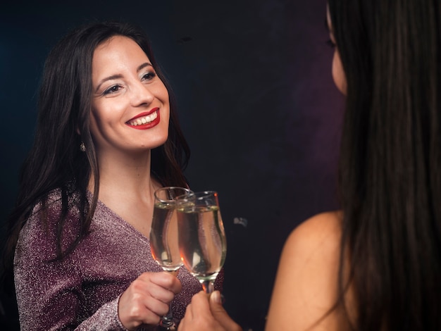 Friends looking at each other with champagne at new years party