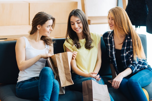 Friends looking at purchases on sofa