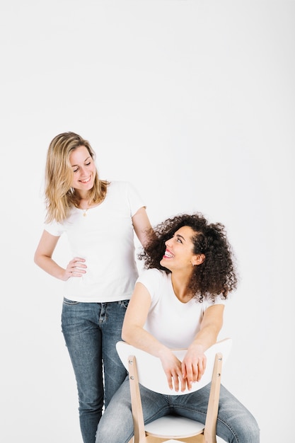 Free photo friends near chair looking at each other