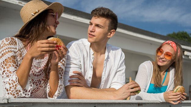 Friends outdoors enjoying burgers together