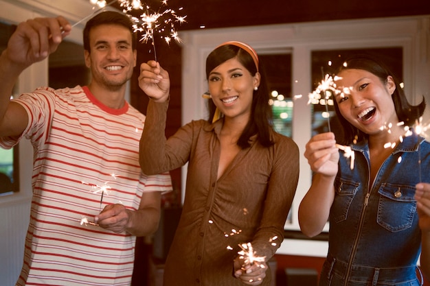 Foto gratuita amici che fanno festa con fuochi d'artificio a tiro medio