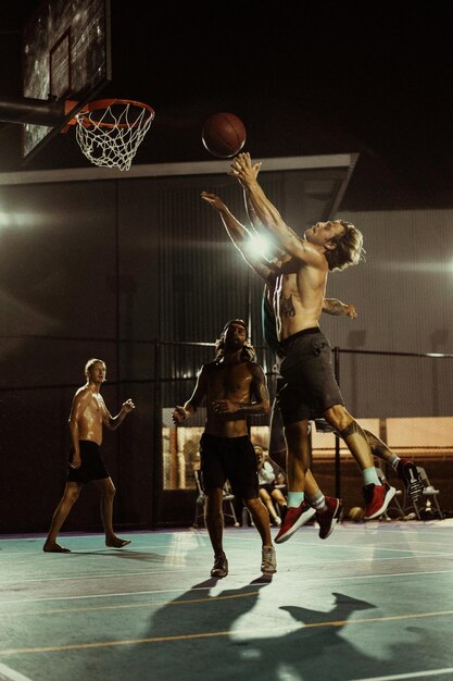 Friends play basketball. Young men play basketball in the street.