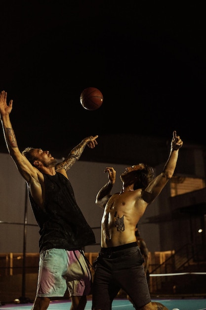 Friends play basketball. Young men play basketball in the street.