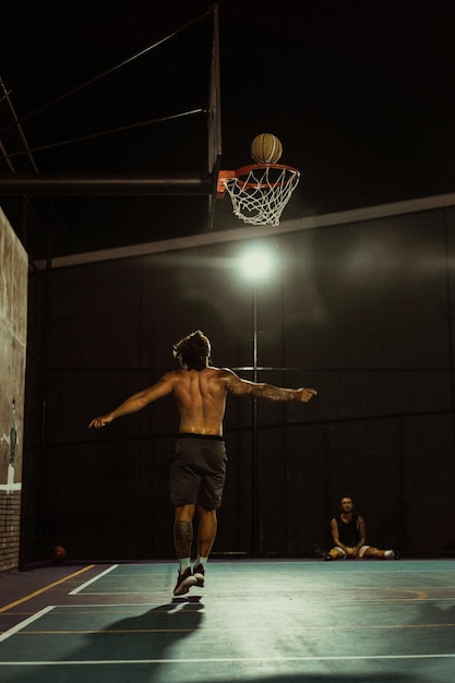 Foto gratuita gli amici giocano a basket. i giovani giocano a basket per strada.