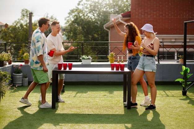 Friends playing beer pong  full shot