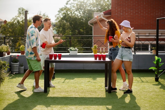 Friends playing beer pong  full shot