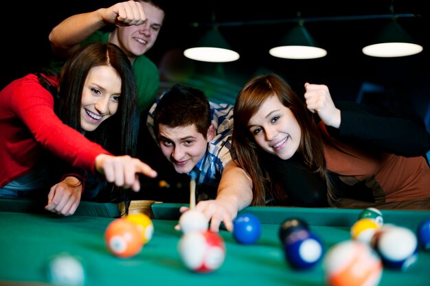 Friends playing billiard