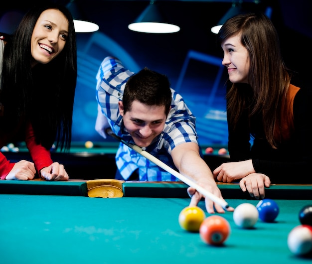 Free photo friends playing billiard