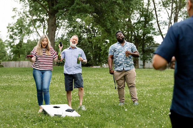 公園の夏のパーティーでコーンホールを遊んでいる友達