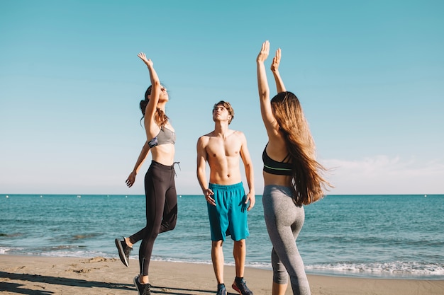 Amici che giocano a pallavolo in spiaggia