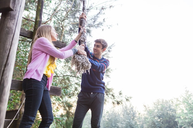 Free photo friends playing with a rope in the park