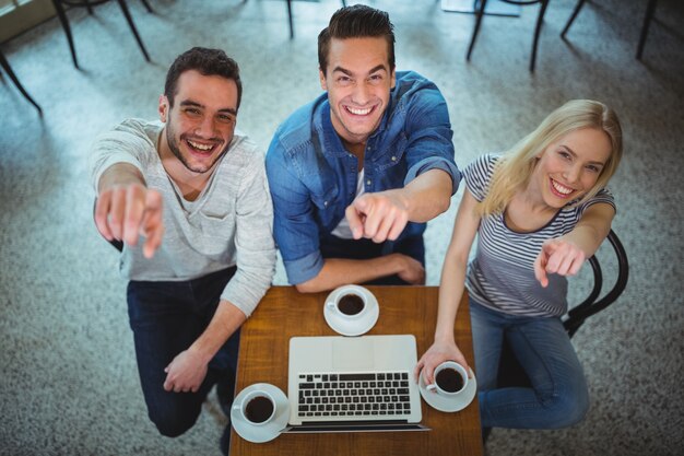 Friends pointing at camera while having black coffee