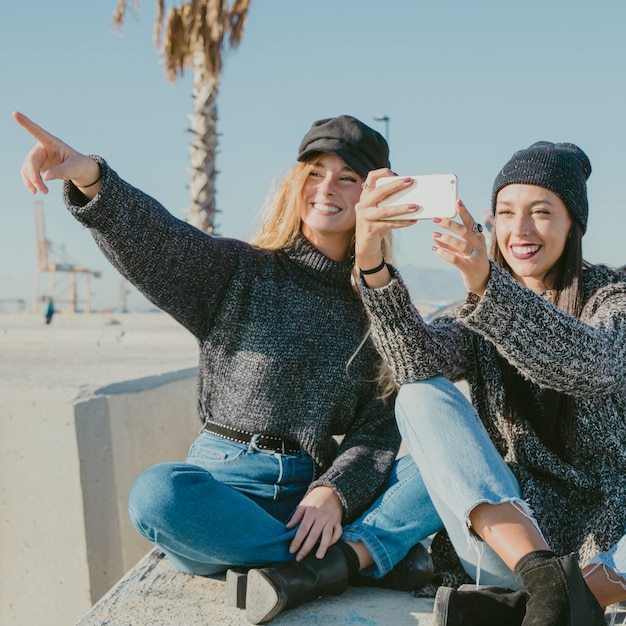 Foto gratuita amici che indicano e prendendo selfie