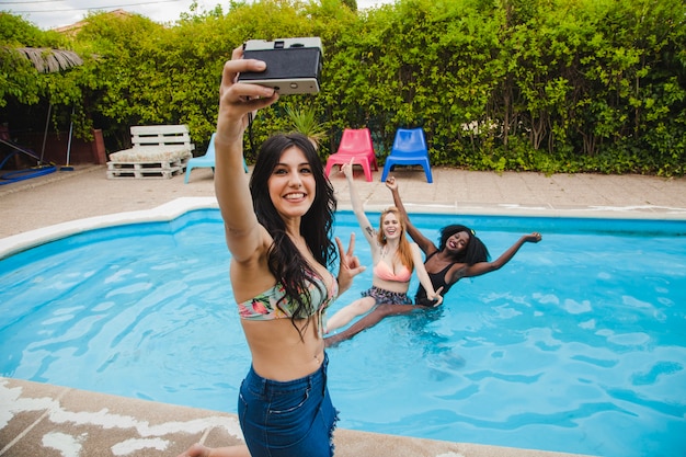 Foto gratuita gli amici posano per selfie in piscina