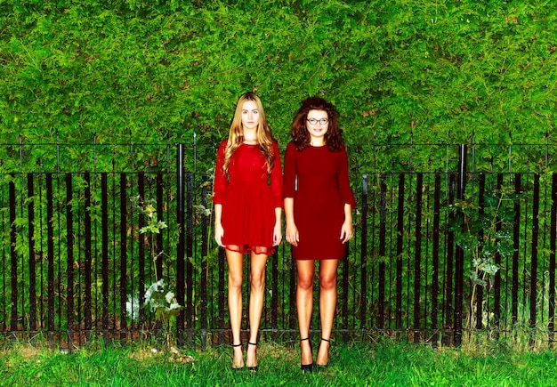 Free photo friends posing with red dresses