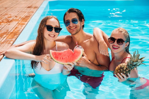 Friends posing with watermelon and pineapple 