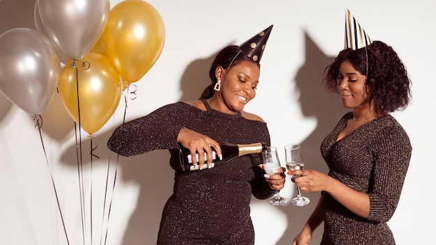 Foto gratuita amici versando bicchieri di champagne festa di buon compleanno