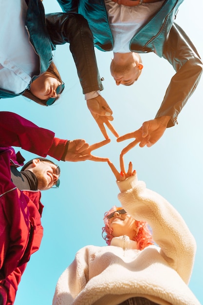 Free Photo friends putting together hands with peace gesture