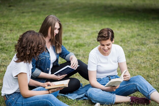 Friends reading together on grass