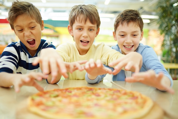 Free photo friends ready to grab slice of pizza