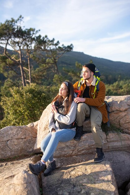 秋のハイキングで休んでいる友達。ハイキングの弾薬が座っているカジュアルな服装の男性と女性。自然、活動、趣味の概念
