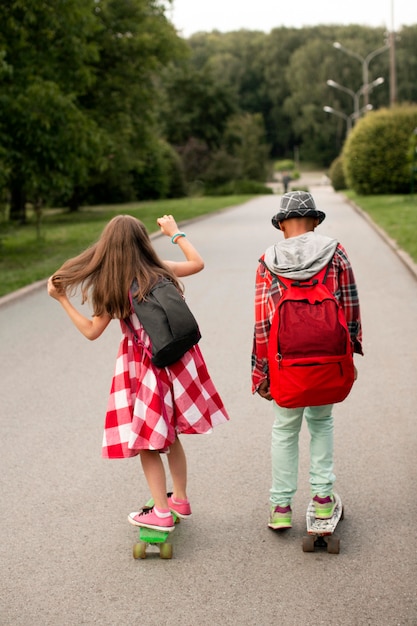 Free photo friends riding skateboard in park