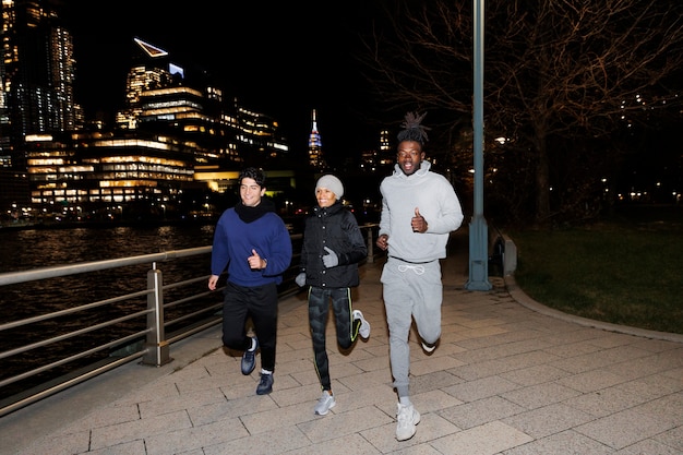 Friends running at night by a river in the city