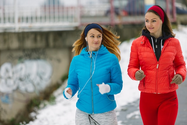 Foto gratuita amici che corrono nel parco di inverno