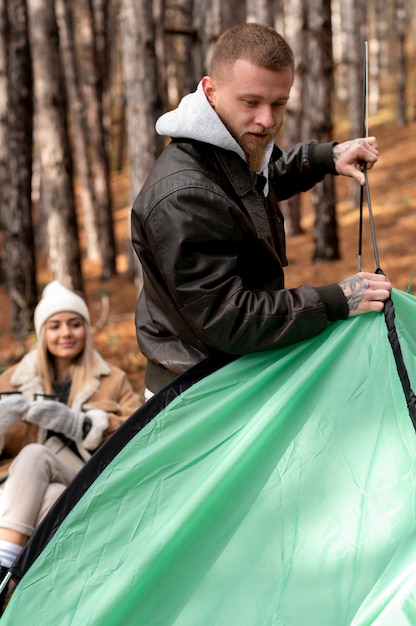 겨울 캠핑 텐트를 설정하는 친구들
