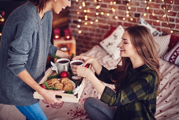 Friends sharing snack in bedroom