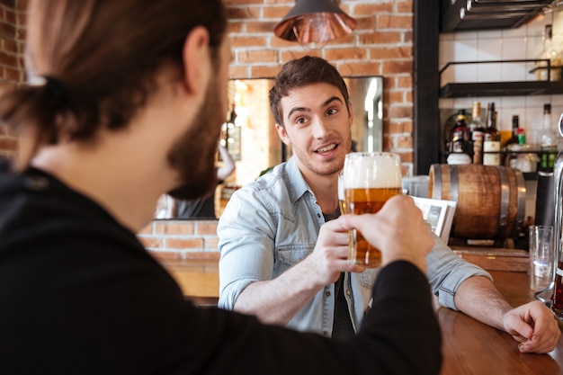 Friends sitting on bar and drinking