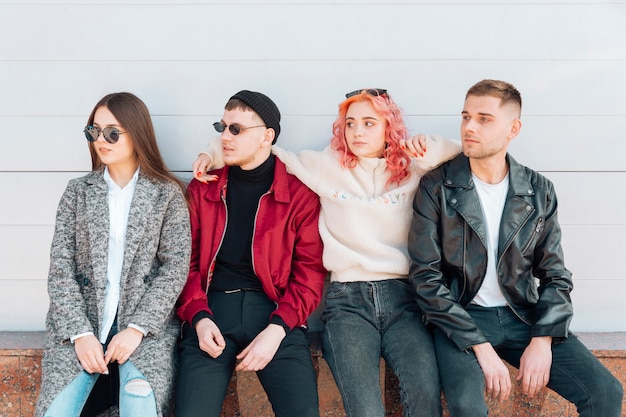 Friends sitting on bench and looking in same direction 