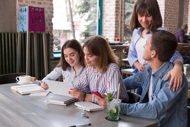 Friends sitting in cafe with tablet