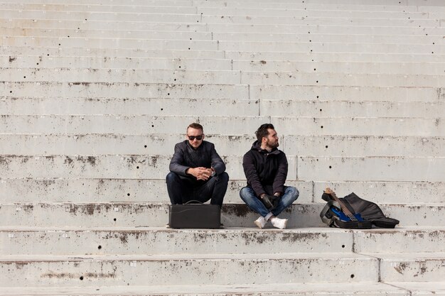 Друзья сидят на бетонной лестнице