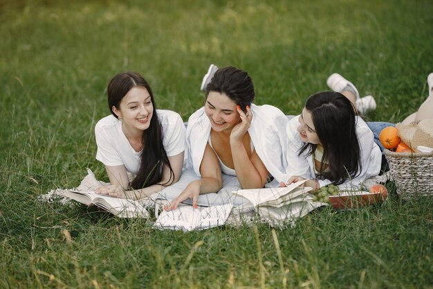 잔디에 앉아 친구입니다. 담요에 여자. 흰 셔츠에 여자입니다.