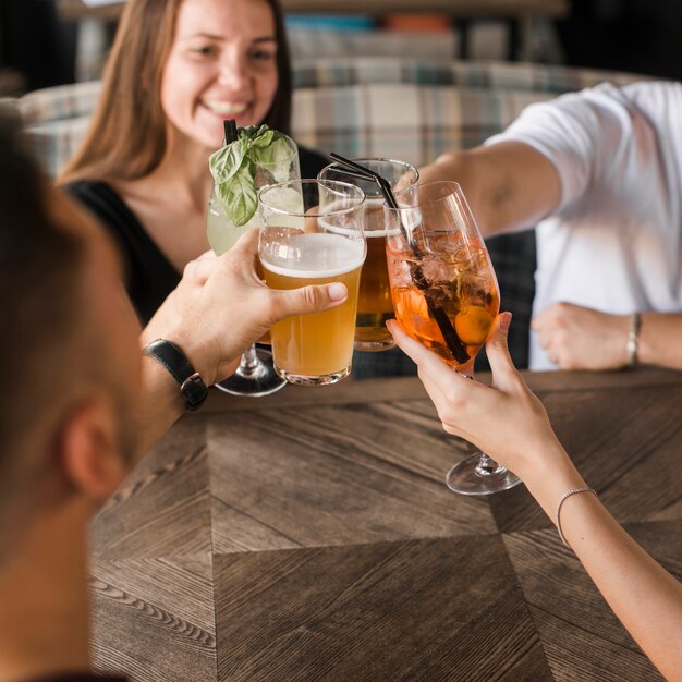 バーで一緒に座っている友人たちが飲み物をトースト