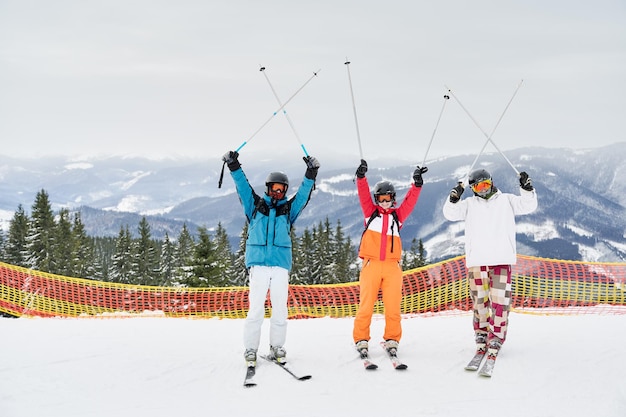 Friends skiers having fun at ski resort in the mountains in winter skiing and snowboarding