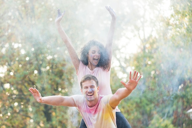 Foto gratuita amici che sorridono e che posano con la polvere colorata