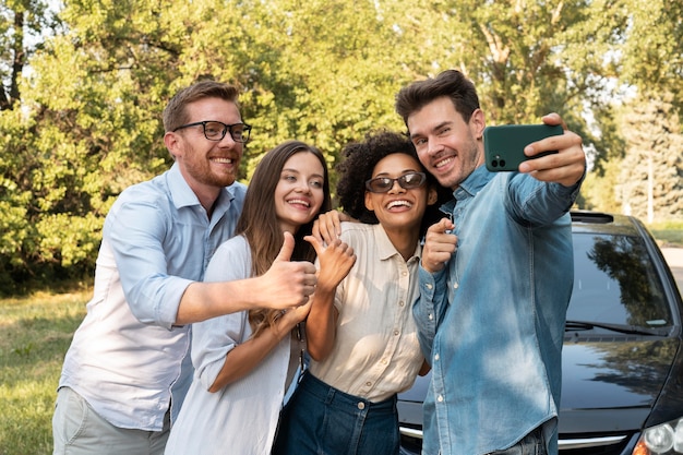 Free photo friends spending time together outdoors and taking selfie