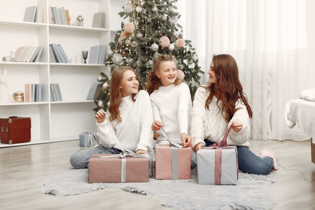 Friends spent time at home. Two girls with Christmas gift. Sisters together.