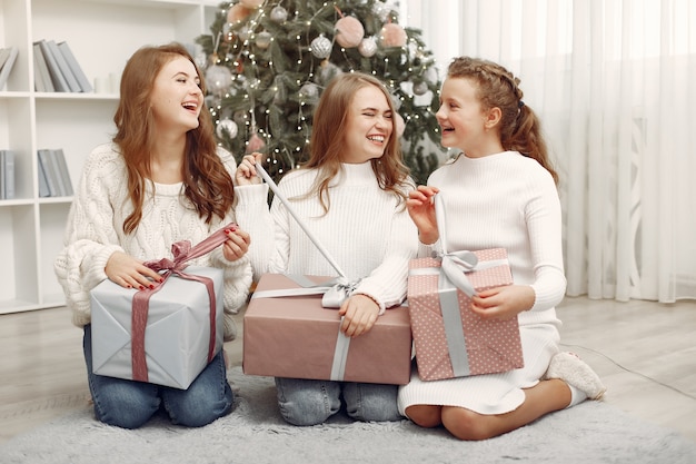 Foto gratuita gli amici trascorrevano del tempo a casa. due ragazze con un regalo di natale. sorelle insieme.