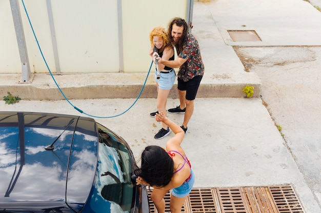 お友達と車の近くに立っている女性に水をはね