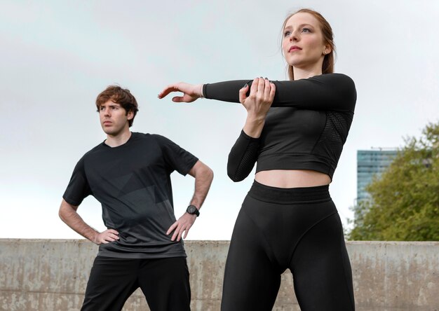 Friends in sportswear exercising outdoors