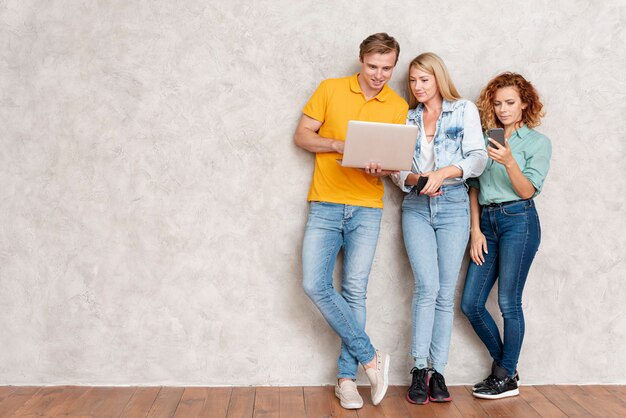 Friends standing and checking their devices