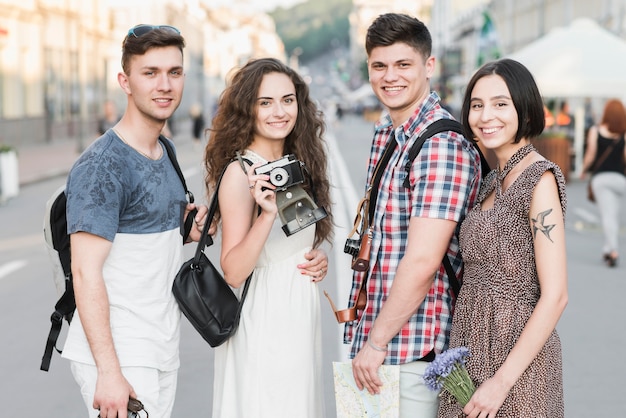 Friends standing on street with camera and map