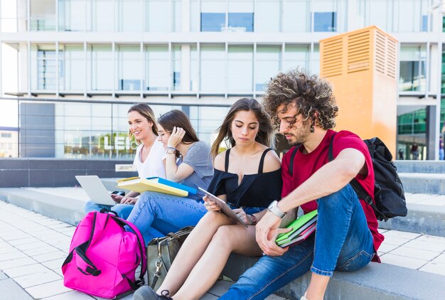 Friends studying on city street